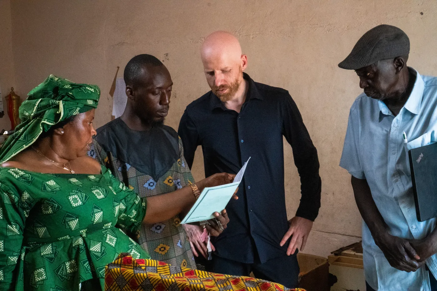 Shane reviewing paperwork with local partners during a field visit in The Gambia